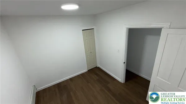 an empty room with wooden floor and closet