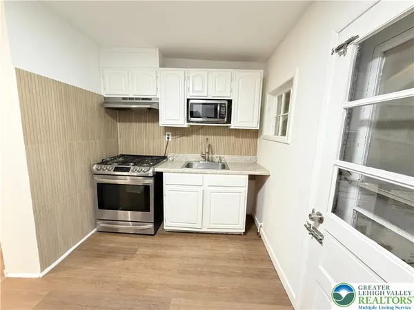 a kitchen with stainless steel appliances a stove microwave and refrigerator