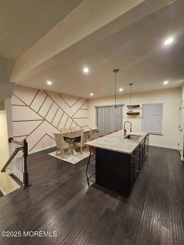 a kitchen with a sink and wooden floor