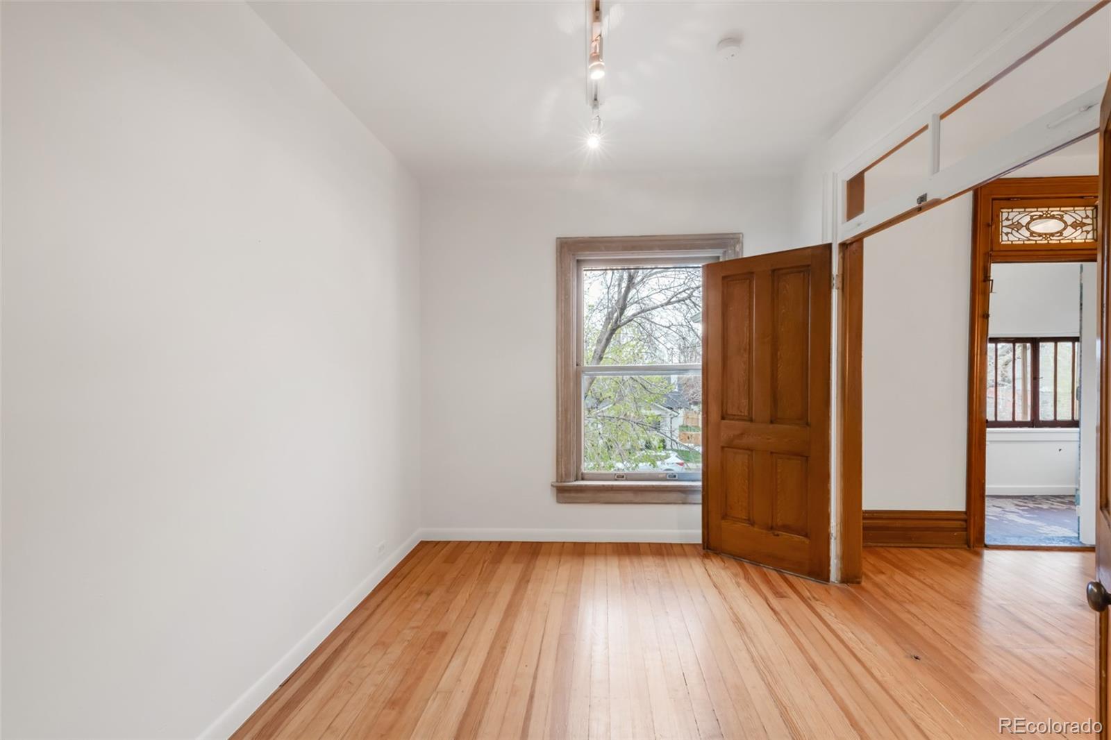 3905 Tejon Street Denver, CO 80211 - Photo 29 of 47 an empty room with wooden floor and windows