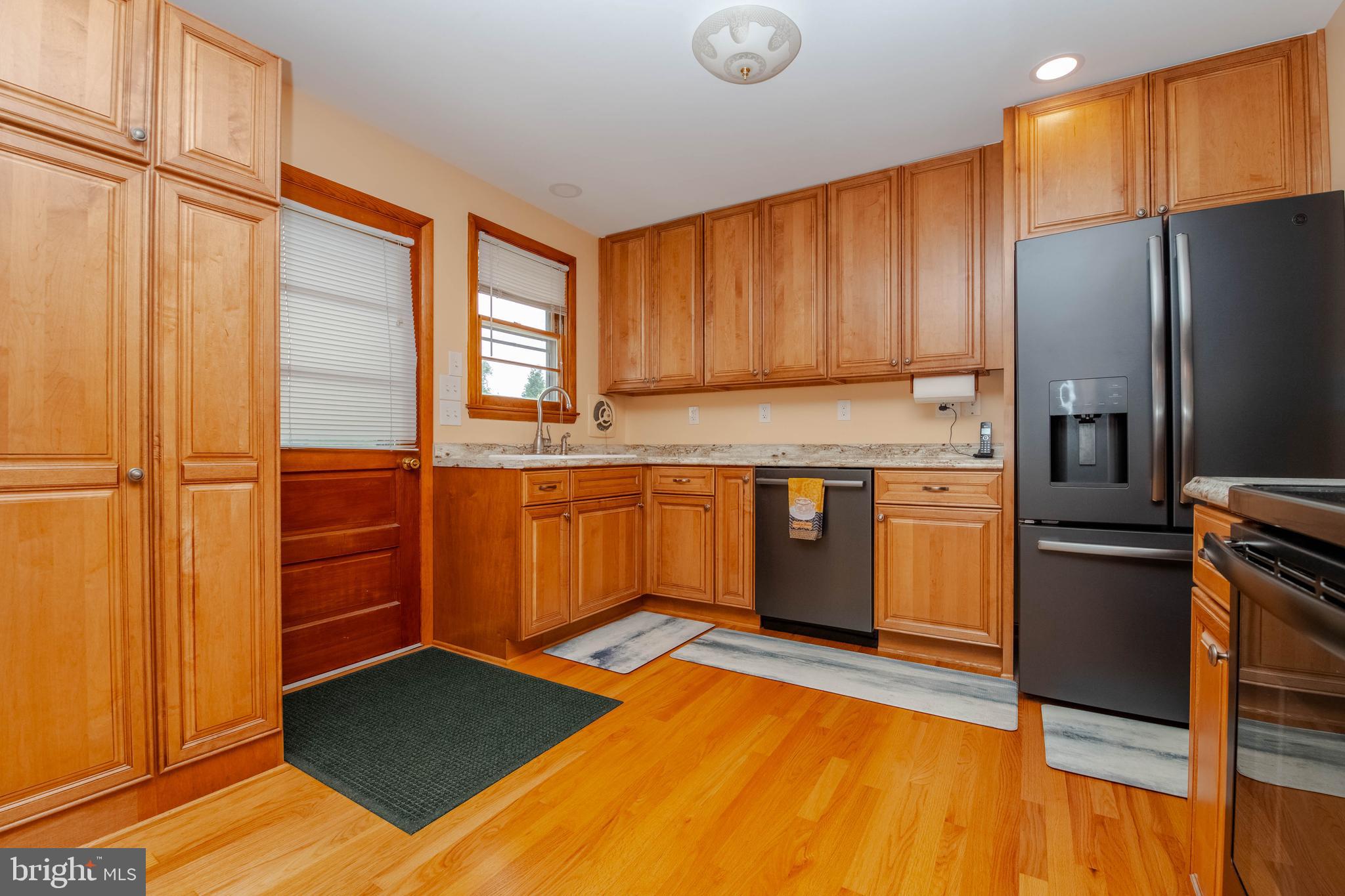 2319 Reckord Road Joppa, MD 21085 - Photo 3 of 45 a kitchen with stainless steel appliances granite countertop a refrigerator a stove and a sink with wooden cabinets