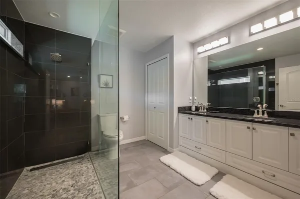 a bathroom with double vanity and a shower