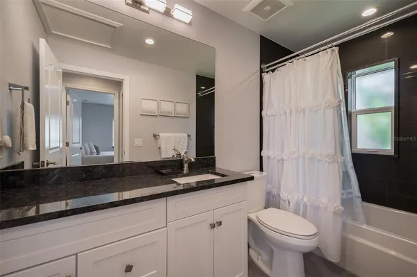 a bathroom with a double vanity sink toilet and shower