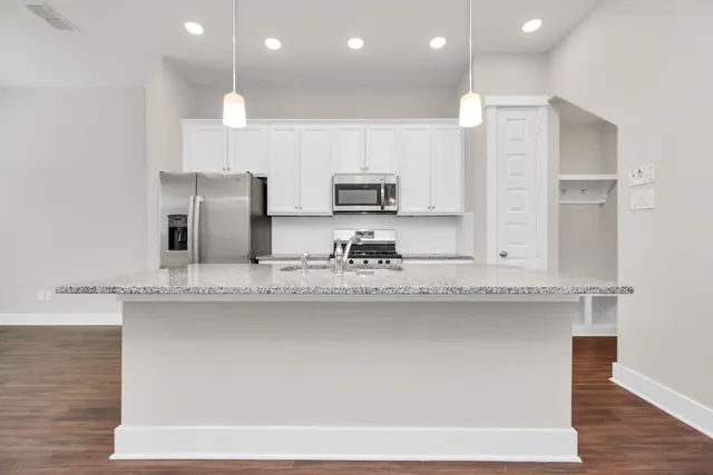 a kitchen with stainless steel appliances granite countertop a sink a stove and a refrigerator