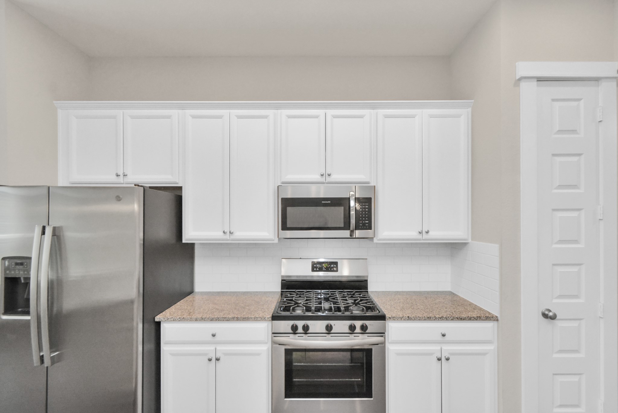 746 Strawberry Pines Court Houston, TX 77009 - Photo 16 of 50 a kitchen with stainless steel appliances granite countertop white cabinets and a stove top oven