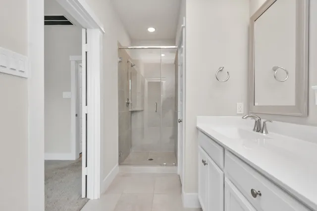 a bathroom with a shower sink and mirror