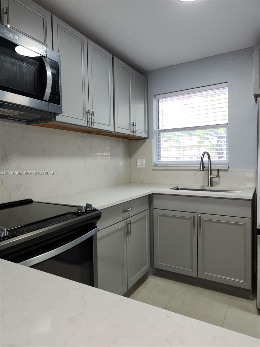 2811 North Pine Island Road, Unit 107 Sunrise, FL 33322 - Photo 1 of 16 a kitchen with a sink and cabinets