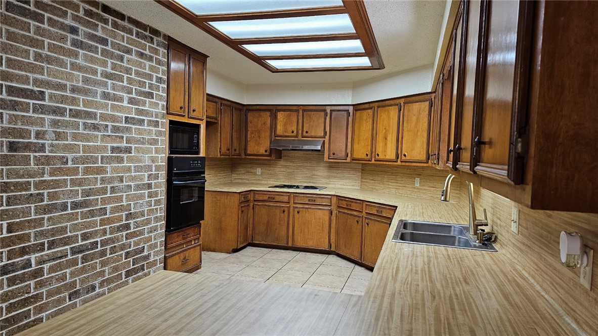 903 Summit Circle Portland, TX 78374 - Photo 12 of 23 a kitchen with stainless steel appliances granite countertop a sink stove and wooden cabinets