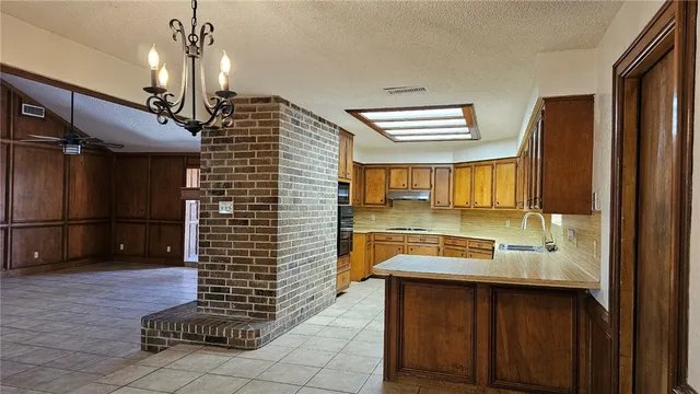a kitchen with a sink stainless steel appliances a counter top space and cabinets