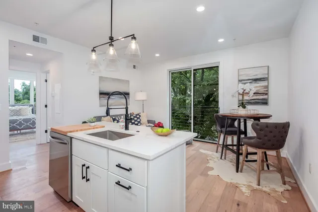 a kitchen that has a sink a stove and a table in it