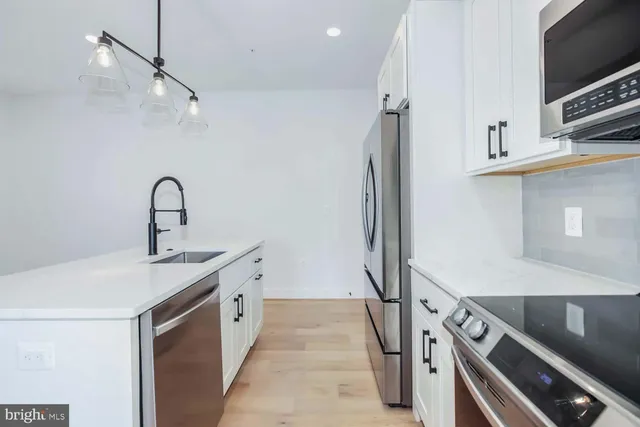 a kitchen with stainless steel appliances a sink and a stove