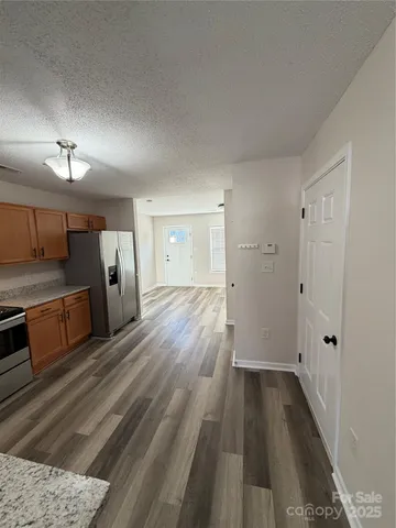 a view of a room with wooden floor and electronic appliances