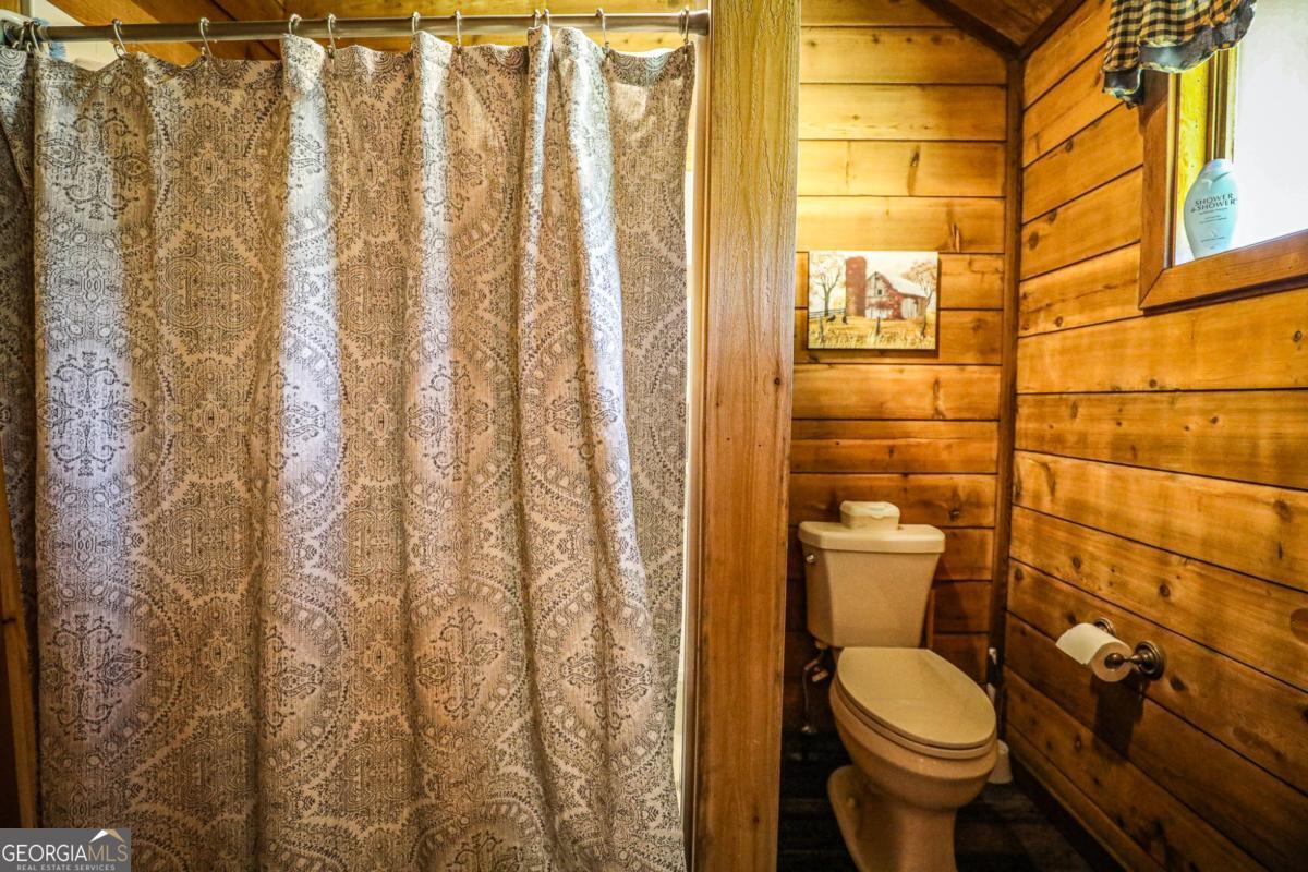75 Deerfield Road Covington, GA 30014 - Photo 20 of 44 a white toilet sitting next to a shower curtain