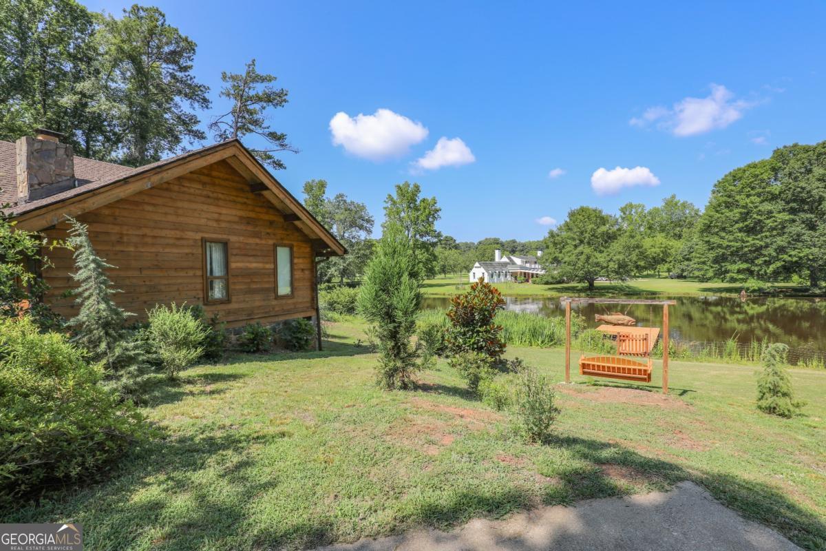 75 Deerfield Road Covington, GA 30014 - Photo 39 of 44 a view of a house with a yard and a pond