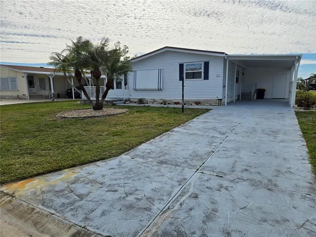 a backyard of a house with potted plants and large tree