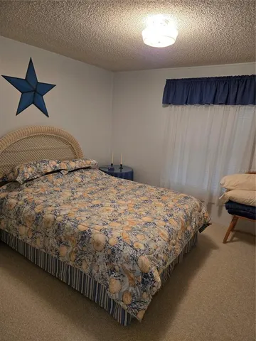 a bed sitting in a bedroom next to a lamp