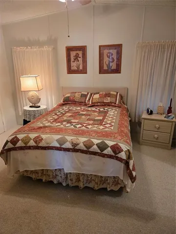 a bed sitting in a bedroom next to a lamp