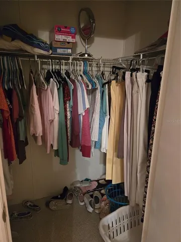 a view of walk in closet with clothes and shoes