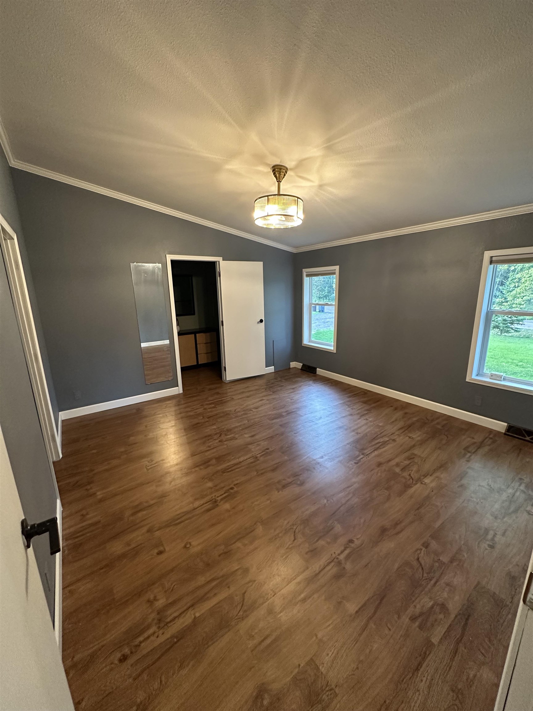 3748 Mulvahill Road Rice Lake, MN 55803 - Photo 12 of 26 Master bedroom featuring ornamental molding, a closet, dark wood-type flooring, and a textured ceiling