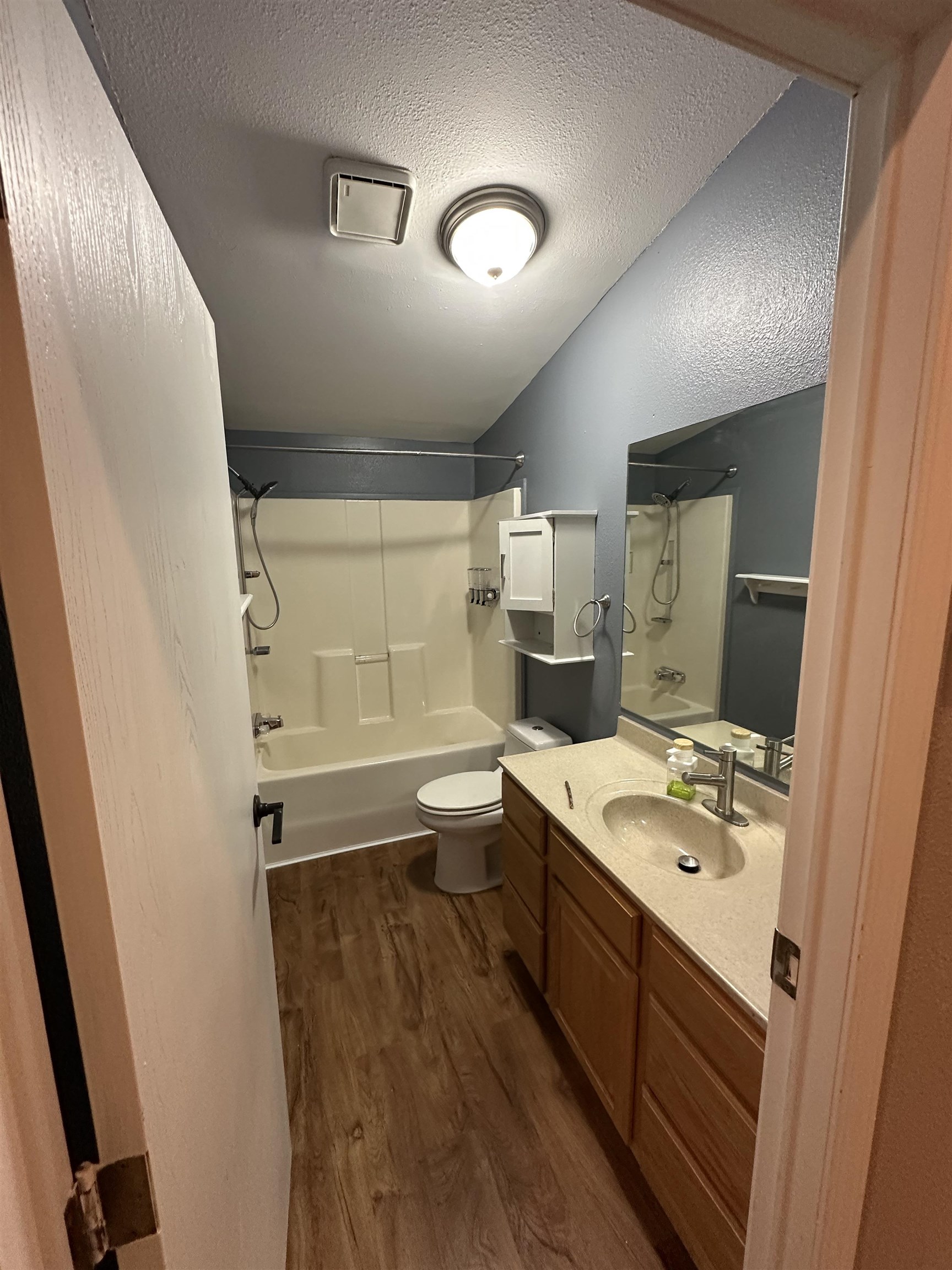 3748 Mulvahill Road Rice Lake, MN 55803 - Photo 16 of 26 Full bathroom featuring bathing tub / shower combination, a textured ceiling, dark wood-style floors, and vanity