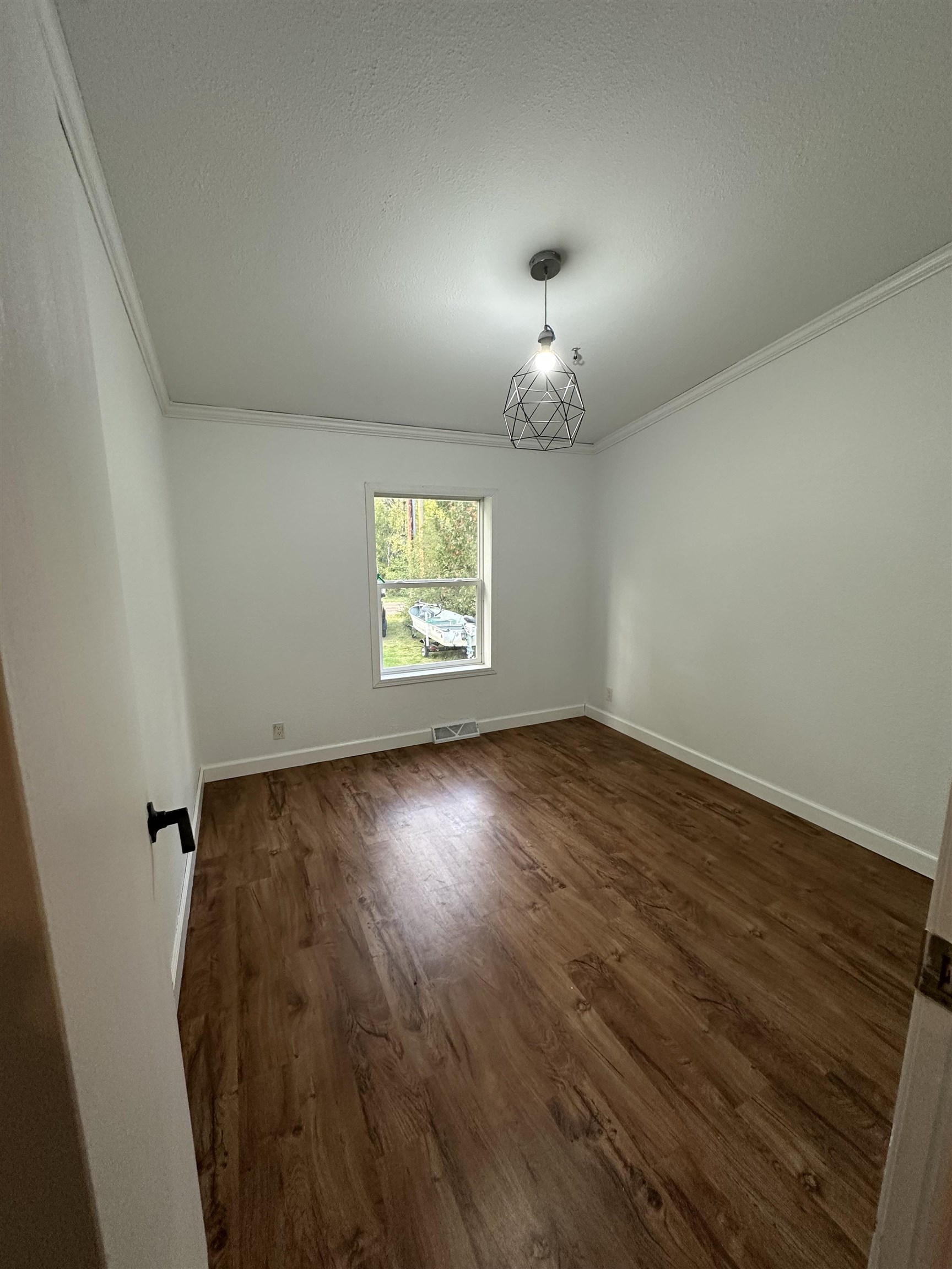 3748 Mulvahill Road Rice Lake, MN 55803 - Photo 17 of 26 Empty room with dark wood-style flooring, crown molding, and a textured ceiling