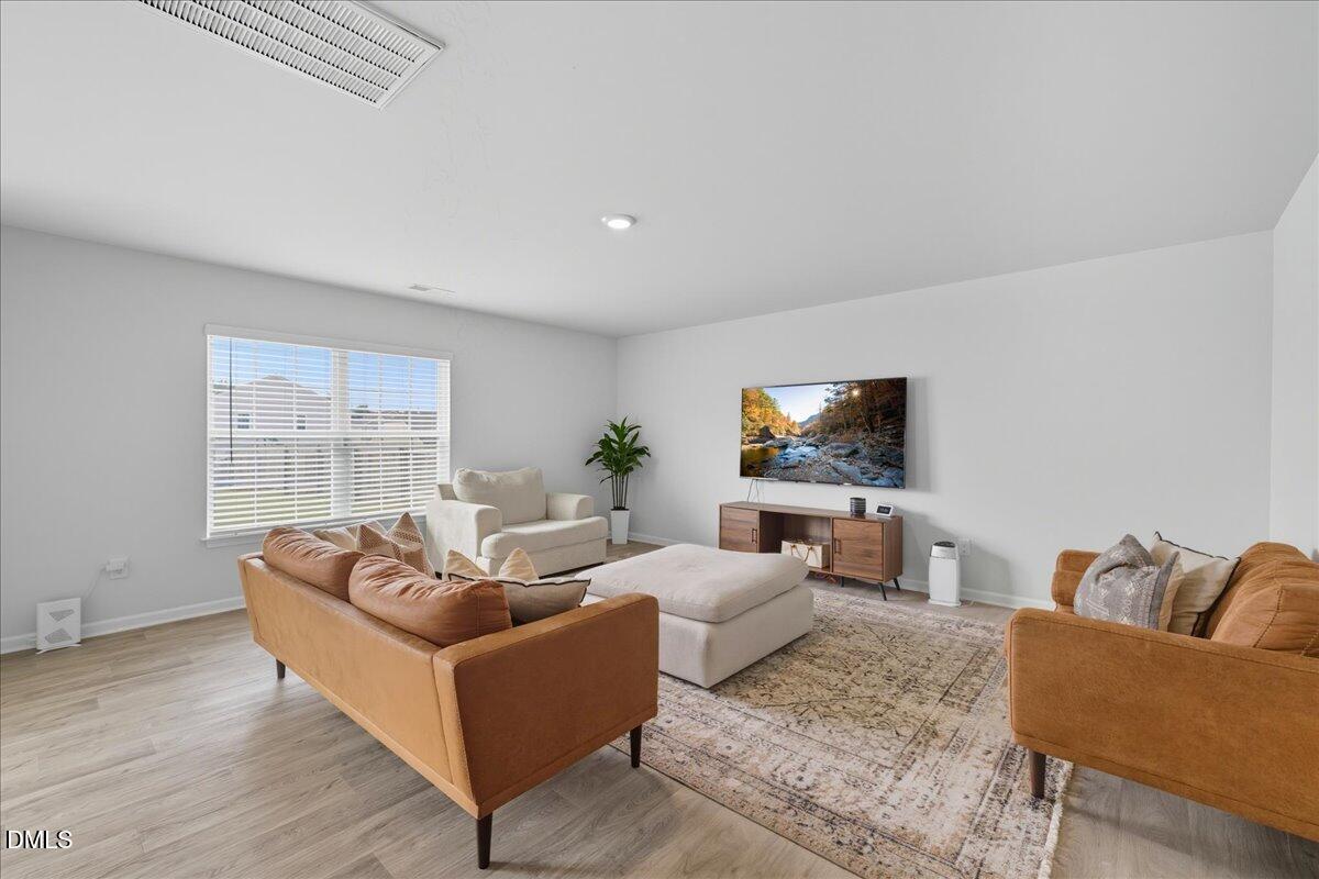 6854 Summerside Drive Whitsett, NC 27377 - Photo 11 of 49 a living room with furniture and a flat screen tv