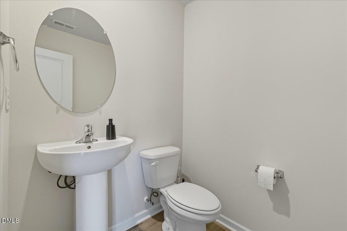 6854 Summerside Drive Whitsett, NC 27377 - Photo 14 of 49 a bathroom with a sink a mirror and toilet