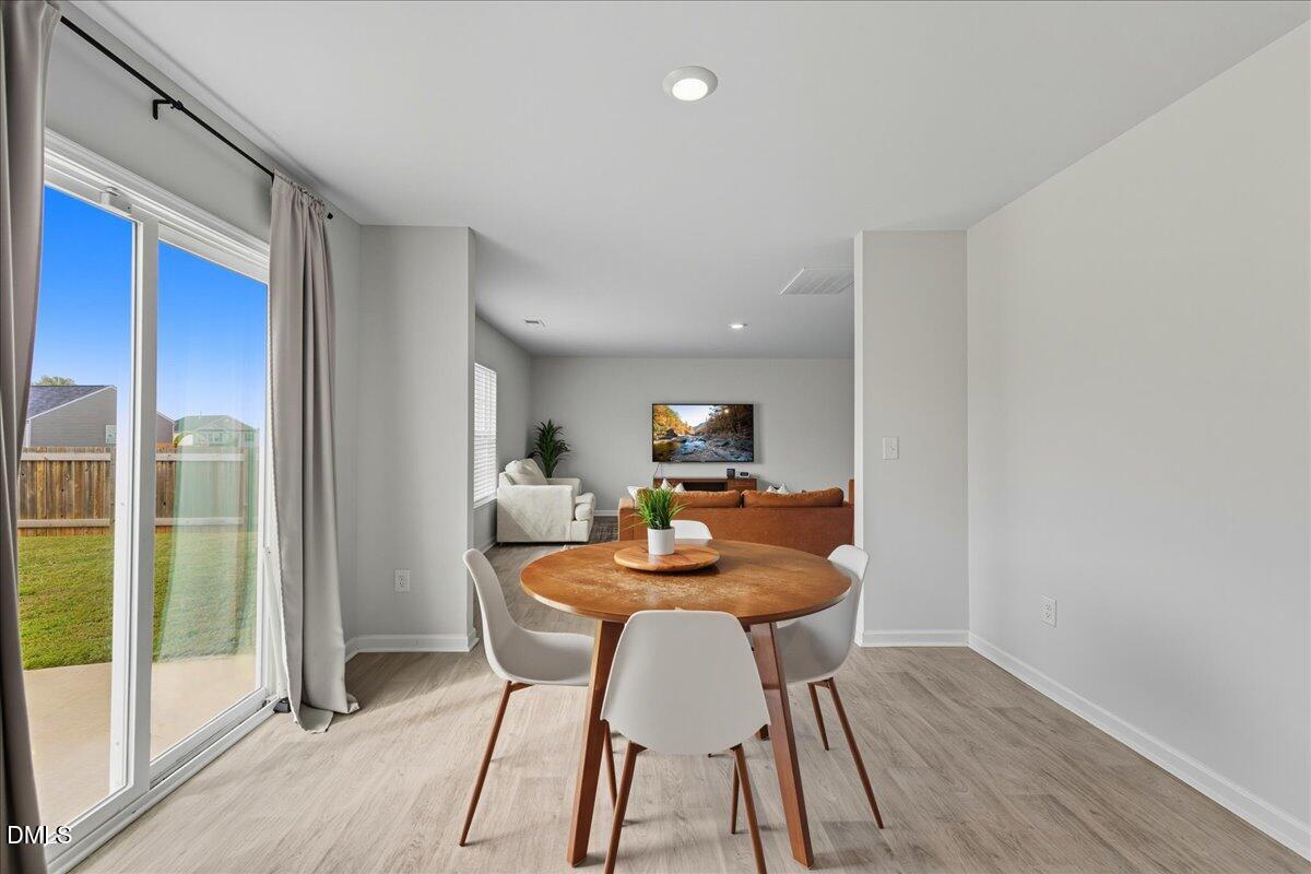 6854 Summerside Drive Whitsett, NC 27377 - Photo 16 of 49 a dining room with furniture and wooden floor