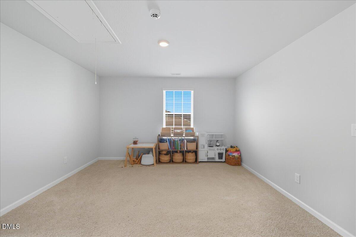 6854 Summerside Drive Whitsett, NC 27377 - Photo 24 of 49 an empty room with chair and window