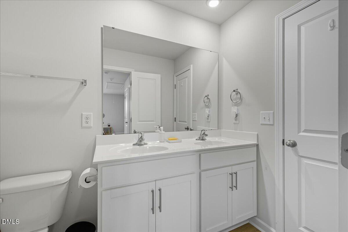 6854 Summerside Drive Whitsett, NC 27377 - Photo 34 of 49 a bathroom with a toilet sink and mirror