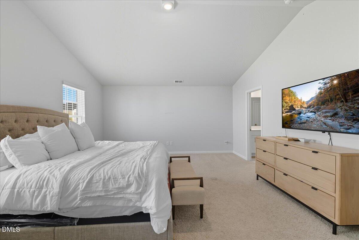 6854 Summerside Drive Whitsett, NC 27377 - Photo 36 of 49 a bedroom with a bed and a flat screen tv