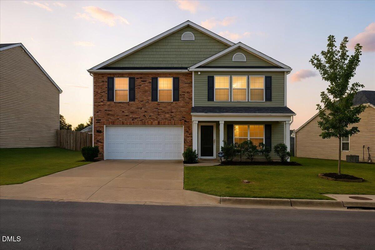 6854 Summerside Drive Whitsett, NC 27377 - Photo 4 of 49 a front view of a house with a yard and garage