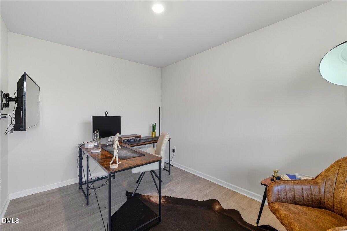 6854 Summerside Drive Whitsett, NC 27377 - Photo 7 of 49 a work room with furniture and wooden floor