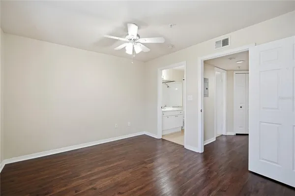 a view of wooden floor and a chandelier fan in a room