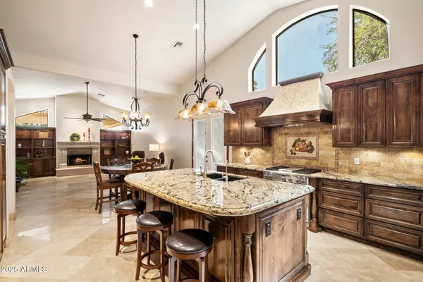 a kitchen with a stove a sink cabinetry and chairs