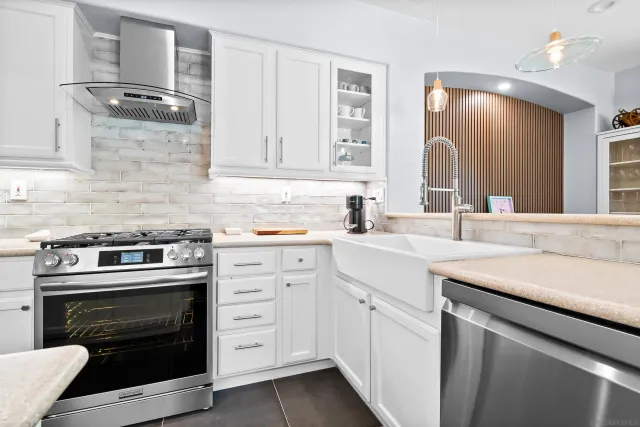 a kitchen with white cabinets and appliances