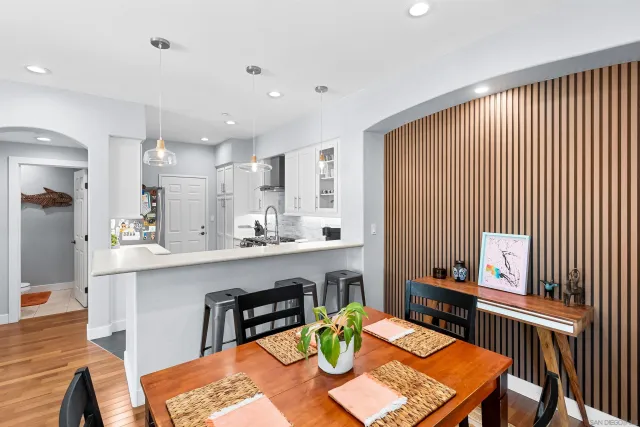 a kitchen with stainless steel appliances kitchen island granite countertop a table chairs sink and cabinets