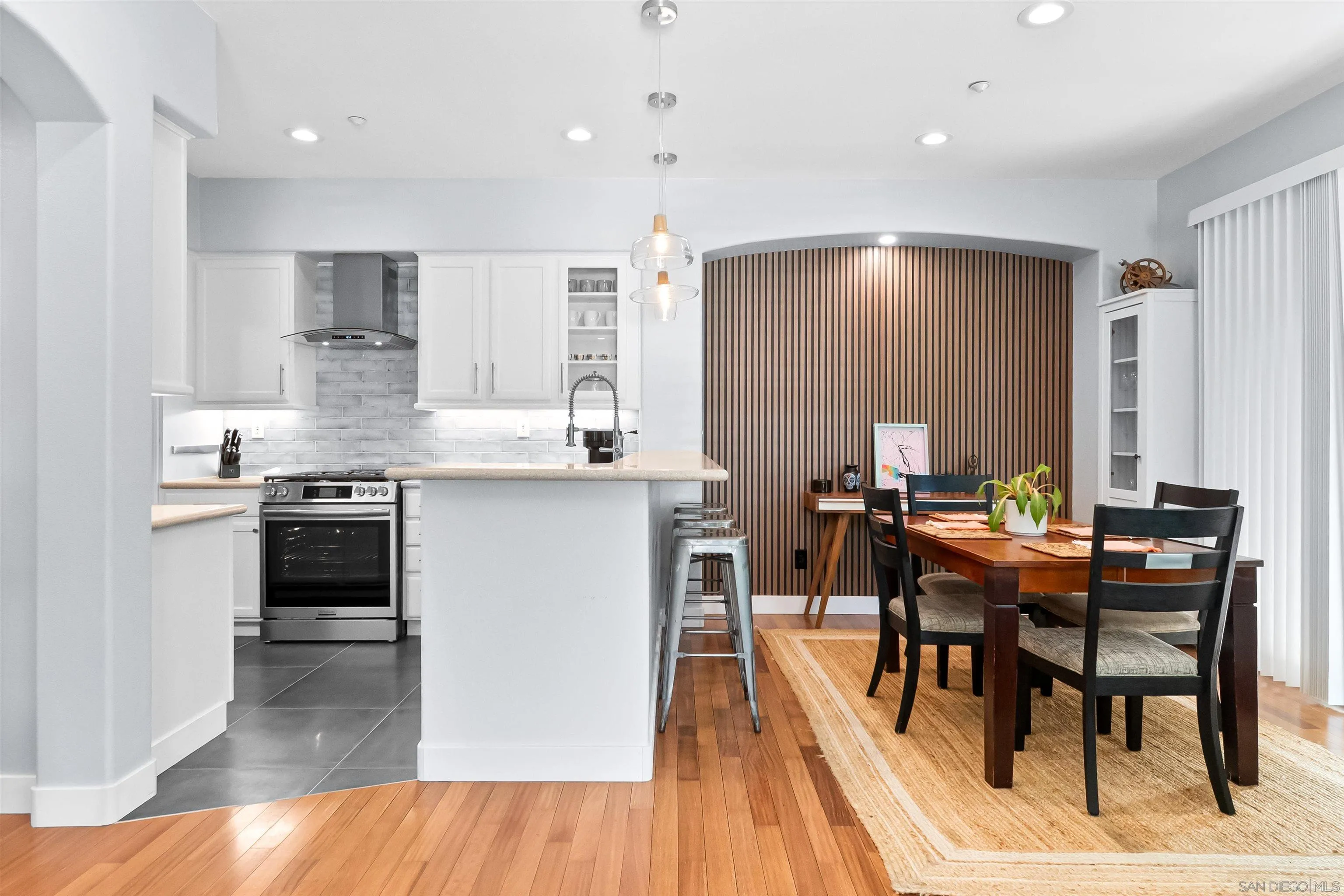 1184 Highbluff Avenue San Marcos, CA 92078 - Photo 21 of 63 a kitchen with stainless steel appliances kitchen island granite countertop a table chairs sink and cabinets