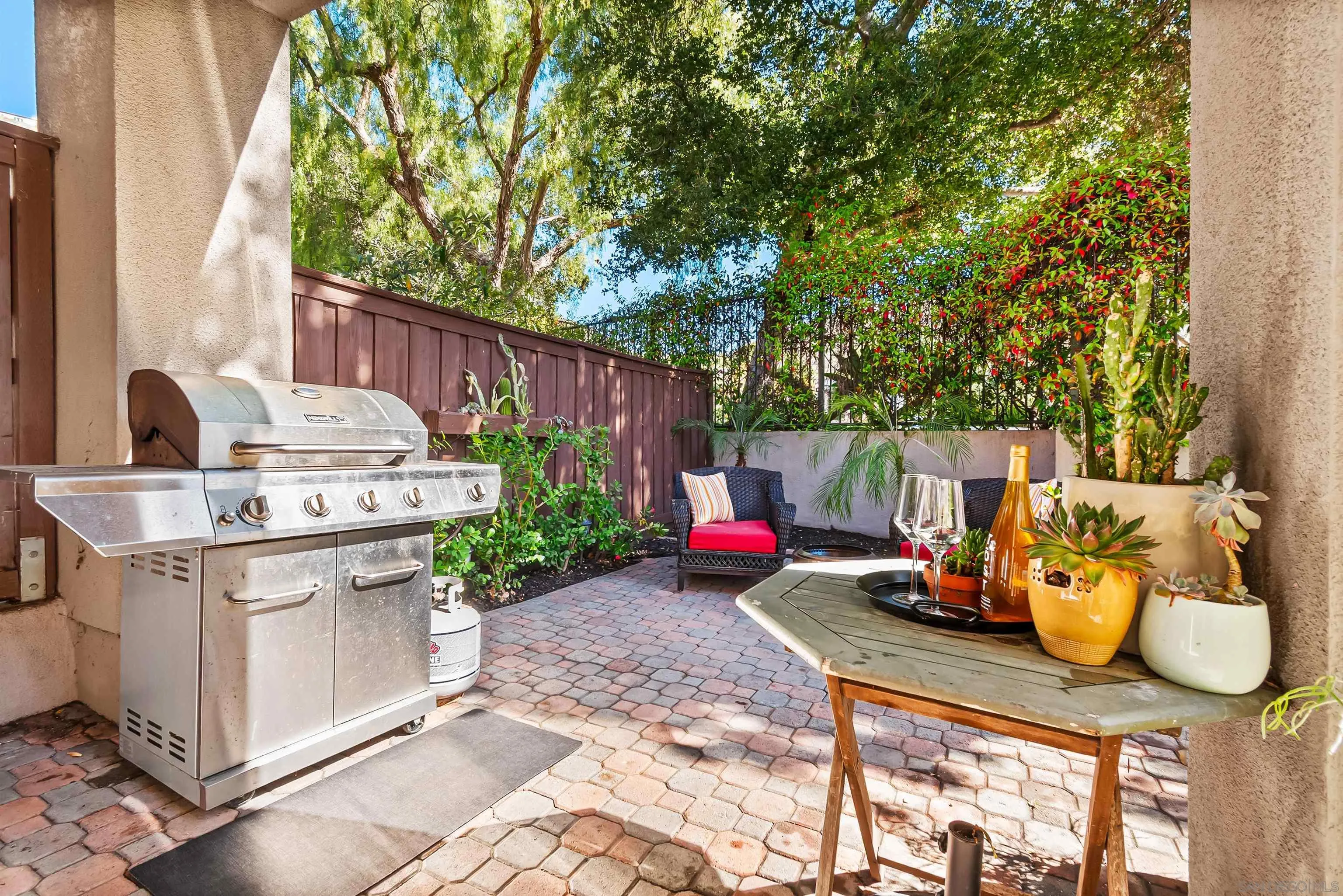 1184 Highbluff Avenue San Marcos, CA 92078 - Photo 42 of 63 a view of a patio with table and chairs potted plants and large tree