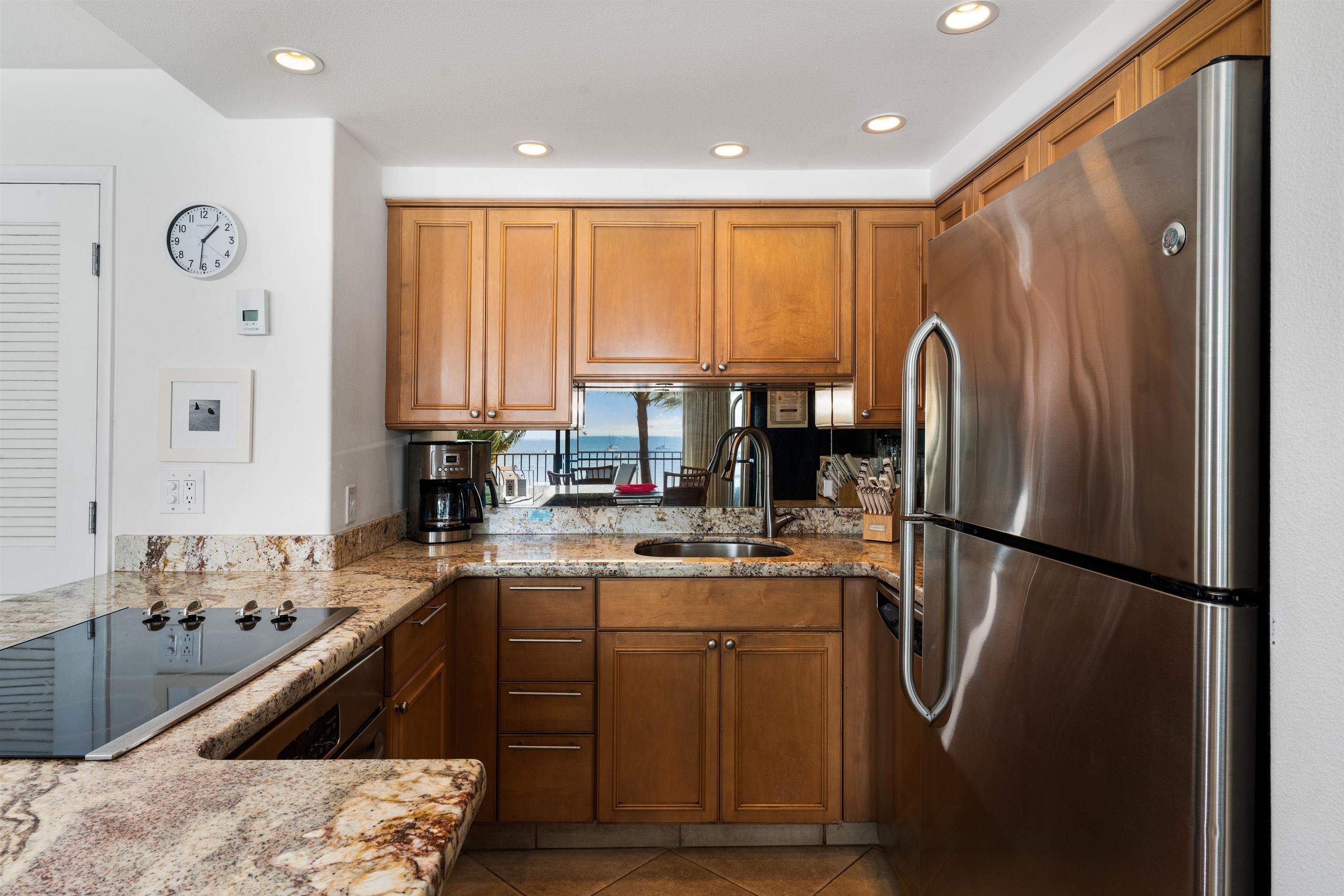 36 South Kihei Road, Unit 603 Kihei, HI 96753 - Photo 8 of 37 a kitchen with stainless steel appliances granite countertop a refrigerator a sink dishwasher a stove and white countertops with wooden floor