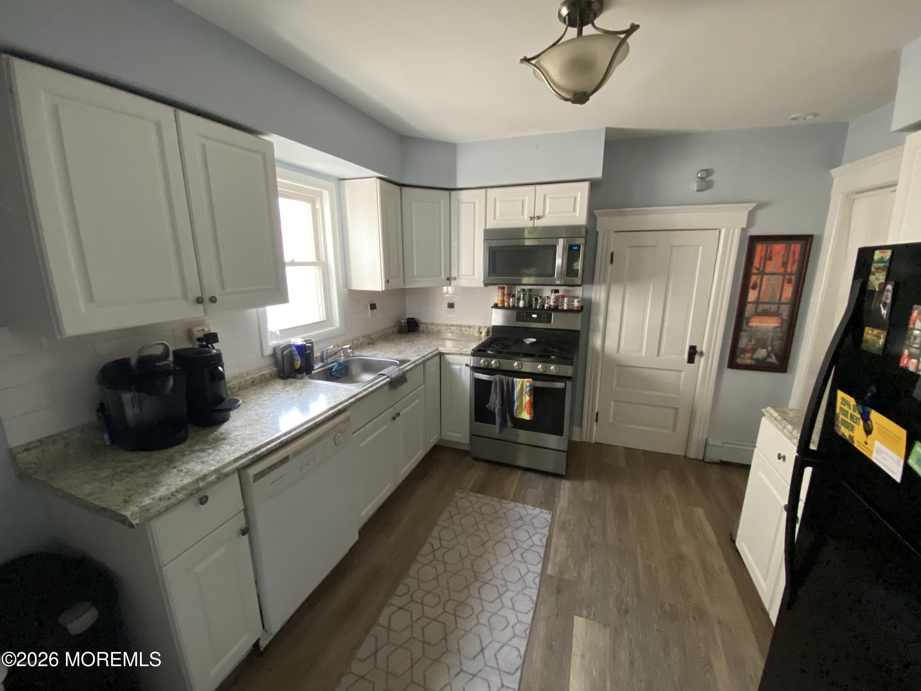 1302 L Street Belmar, NJ 07719 - Photo 5 of 14 a kitchen with stainless steel appliances a refrigerator a sink a stove and cabinets