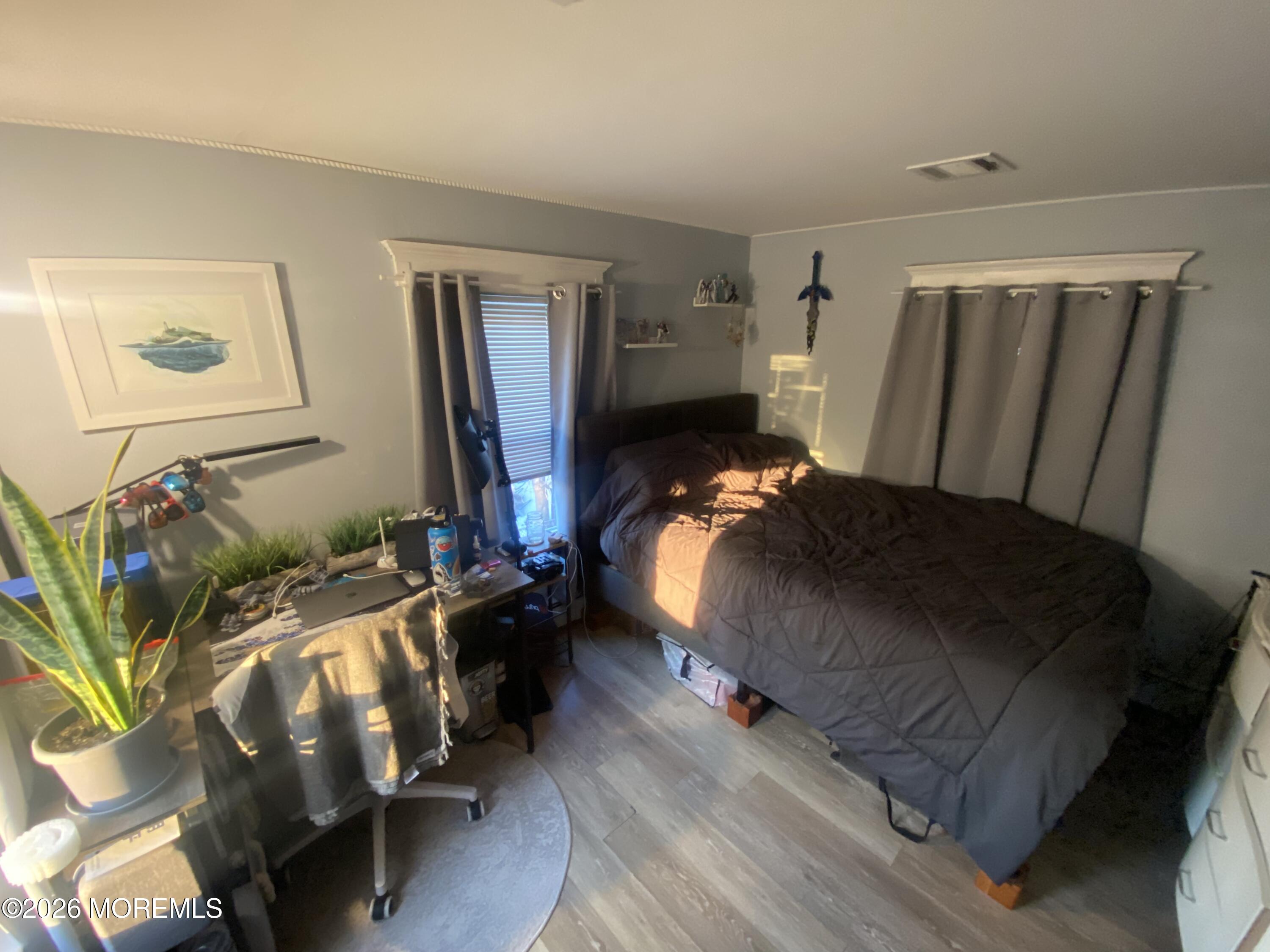 1302 L Street Belmar, NJ 07719 - Photo 6 of 14 a bedroom with a bed and wooden floor