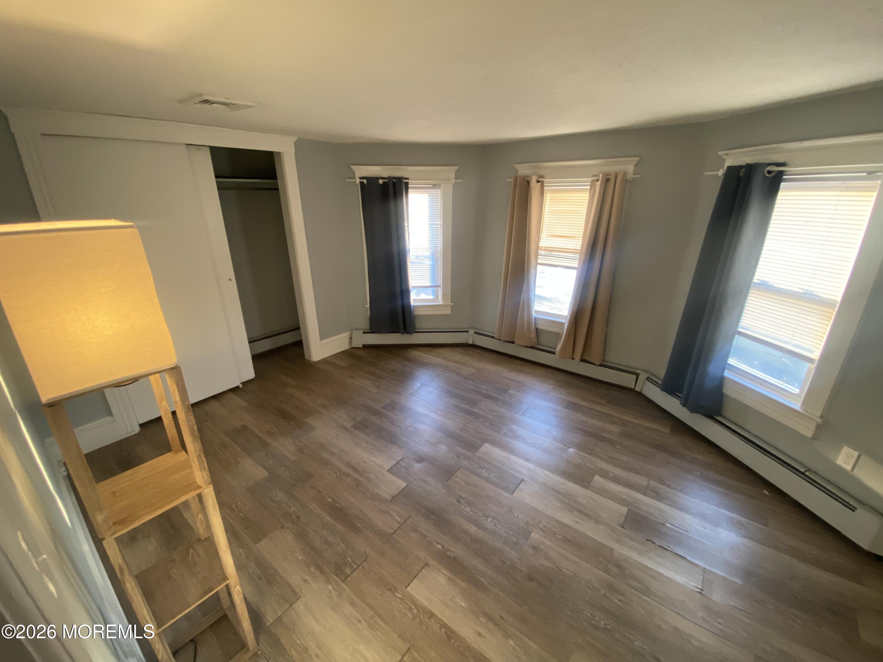 1302 L Street Belmar, NJ 07719 - Photo 7 of 14 a view of an empty room with wooden floor and a window