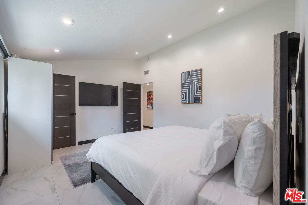 20412 Oxnard Street Woodland Hills, CA 91367 - Photo 11 of 35 a spacious bedroom with a bed and a television