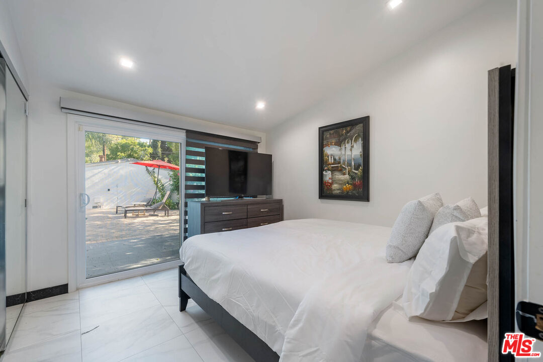 20412 Oxnard Street Woodland Hills, CA 91367 - Photo 12 of 35 a bedroom with a large bed and a large window