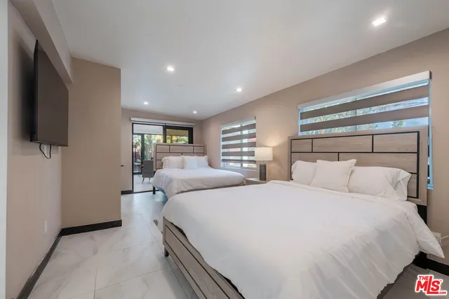 a bedroom with a bed and a flat screen tv