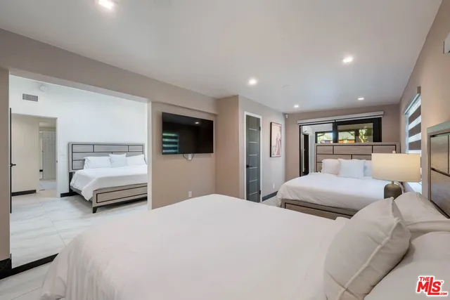 a bedroom with a large bed and a tv