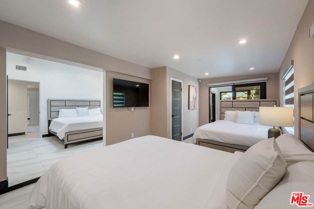 20412 Oxnard Street Woodland Hills, CA 91367 - Photo 17 of 35 a bedroom with a large bed and a tv