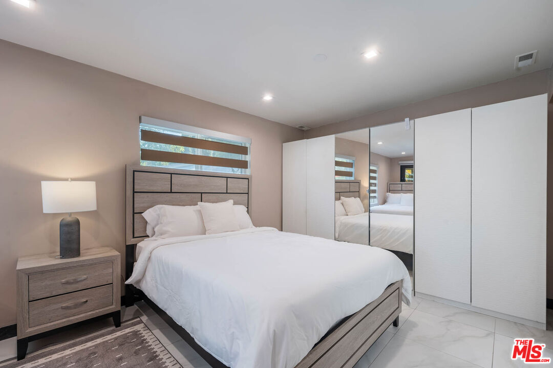 20412 Oxnard Street Woodland Hills, CA 91367 - Photo 19 of 35 a bedroom with a bed and a lamp