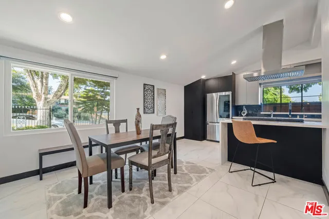 a dining room with kitchen island furniture a large window and chairs